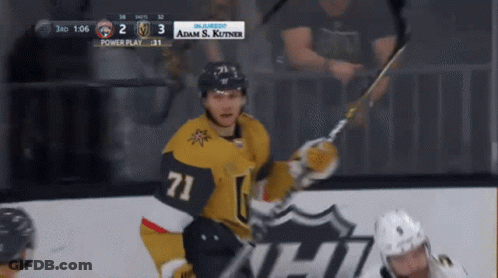 A Hockey Player With The Number 71 On His Jersey Holds A Hockey Stick GIF