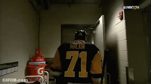A Hockey Player With The Number 71 On His Jersey Walks Through A Doorway GIF
