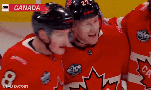 A Hockey Player With The Number 8 On His Jersey Hugs Another Player GIF