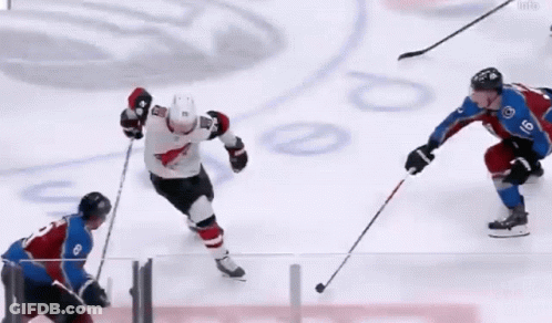 A Hockey Player With The Number 8 On His Jersey Is Playing Against Another Player GIF