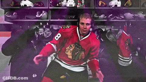 A Hockey Player With The Number 8 On His Jersey Is Sitting In A Locker Room GIF