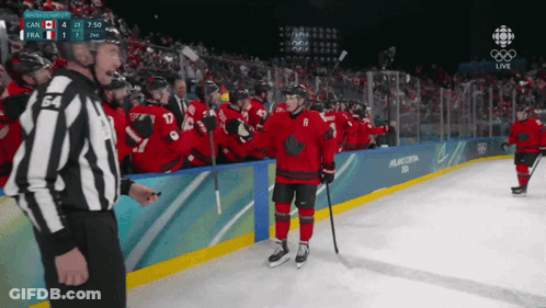 A Hockey Player With The Number 8 On His Jersey Stands On The Ice Surrounded By His Teammates GIF