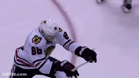 A Hockey Player With The Number 88 On His Jersey Is Holding A Hockey Stick On The Ice . GIF