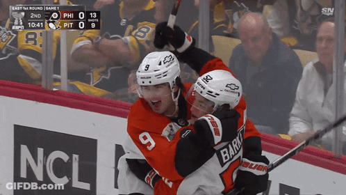 A Hockey Player With The Number 9 On His Jersey Celebrates With Another Player GIF