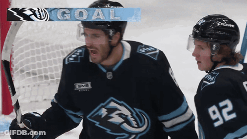A Hockey Player With The Number 92 On His Jersey Stands Next To Another Player GIF