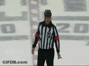 A Hockey Referee Stands On The Ice In Front Of A Sign That Says ' O'zd ' GIF