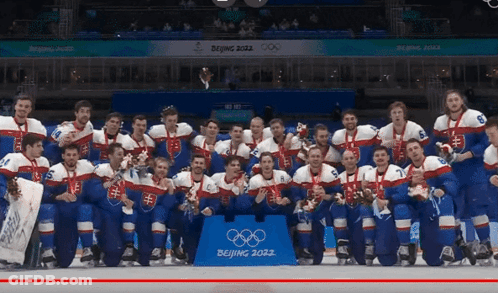 A Hockey Team Poses For A Photo In Front Of A Sign That Says ' Beijing 2022 ' GIF