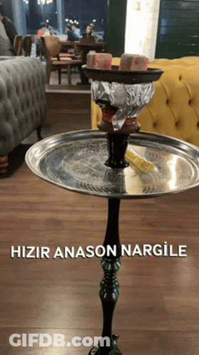 A Hookah Sitting On Top Of A Metal Tray That Says Hizir Anason Nargile On It GIF
