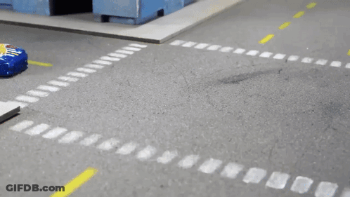 A Hot Wheels Car Is Driving Down A Street GIF