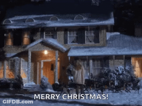 A House Is Covered In Snow At Night And A Sleigh Is Pulling A Christmas Tree . GIF