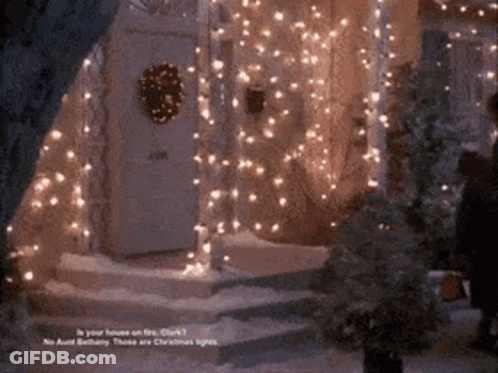 A House Is Decorated With Christmas Lights And A Wreath On The Front Door GIF