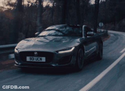 A Jaguar Is Driving Down A Road With A License Plate That Says 901 Ucn GIF