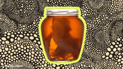 A Jar Of Amber Liquid With A Yellow Border On A Black And White Polka Dot Background GIF