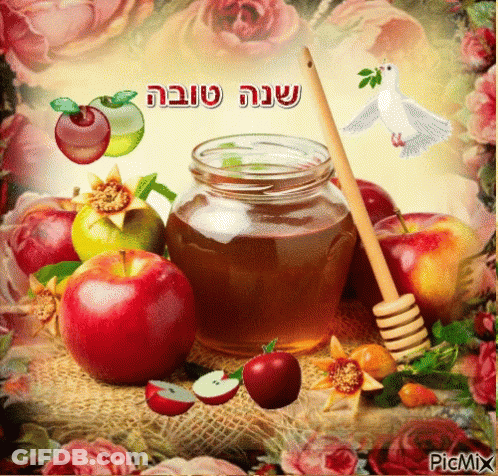 A Jar Of Honey Surrounded By Apples And Flowers With Hebrew Writing On It GIF