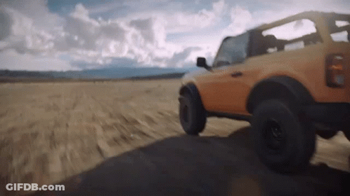 A Jeep Is Driving Down A Dirt Road In The Desert GIF
