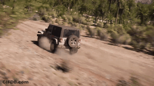 A Jeep Is Driving On A Dirt Road In The Desert . GIF