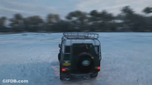 A Jeep Is Driving Through A Snowy Field With A License Plate That Says ' A ' On It GIF