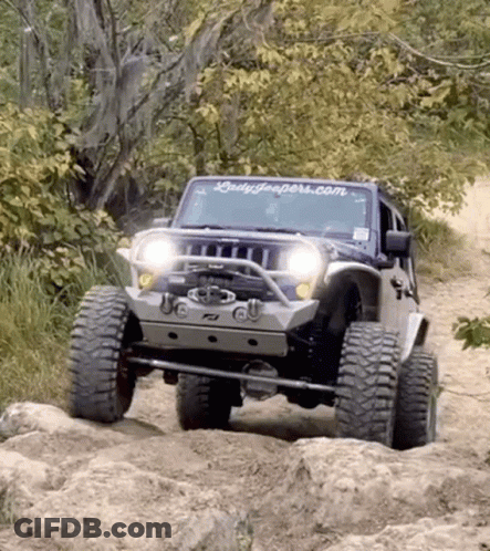 A Jeep With A Ladyjeepers.com Sticker On The Windshield Is Driving Through The Woods GIF