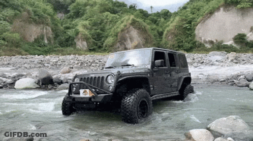 A Jeep With A License Plate That Says ' Jeep ' On It Is Driving Through A River GIF