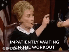 A Judge Is Sitting At A Desk And Pointing At Someone While Waiting On The Workout . GIF