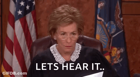 A Judge Is Sitting In A Courtroom Holding A Piece Of Paper And Says `` Lets Hear It '' . GIF