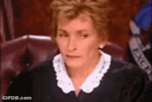 A Judge Is Sitting In A Courtroom Wearing A Black Robe And White Collar . GIF