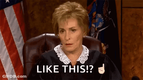 A Judge Is Sitting In A Courtroom With An American Flag In The Background . GIF