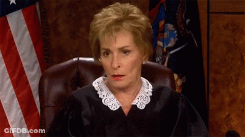 Judge Sitting In Front Of American Flag GIF