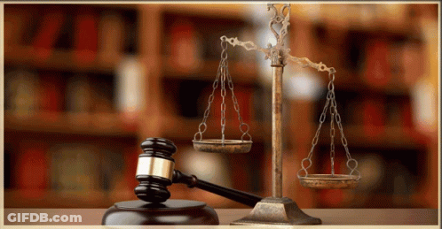 A Judge 'S Gavel And Scales Of Justice Are On A Table GIF