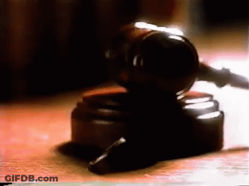 A Judge 'S Gavel Is On A Wooden Table GIF