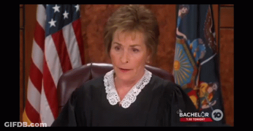 A Judge Sitting In Front Of An American Flag With Bachelor 10 Written On The Bottom GIF