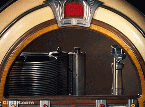 A Jukebox With A Stack Of Cds On The Shelf GIF
