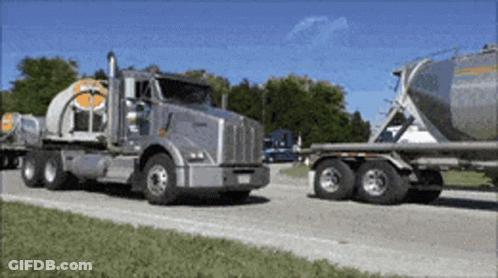 A Kenworth Semi Truck Is Driving Down A Road GIF