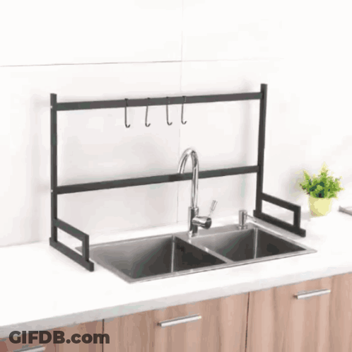 A Kitchen Sink With A Black Rack On Top GIF