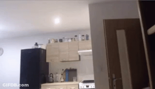 A Kitchen With A Stove And A Refrigerator In It GIF