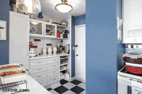 A Kitchen With Blue Walls And White Cabinets Has A Checkered Floor GIF
