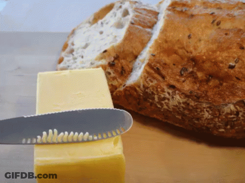 A Knife Is Cutting A Piece Of Butter Next To A Slice Of Bread GIF