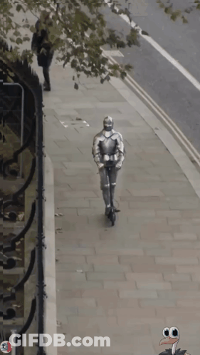 A Knight In Armor Is Walking Down The Street With A Turkey In The Background GIF