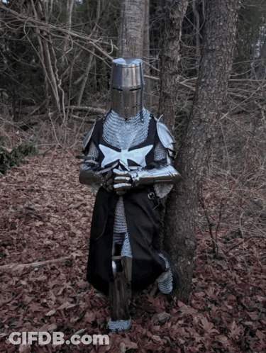 A Knight Leans Against A Tree In The Woods Holding A Sword GIF