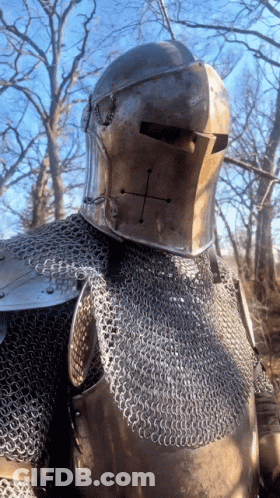 A Knight Wearing Chain Mail And A Helmet With A Cross On His Face GIF