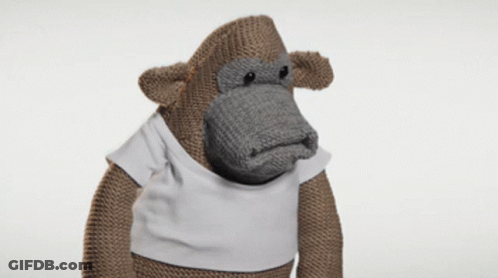 A Knitted Monkey Wearing A White Shirt GIF