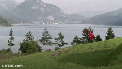A Lake With Mountains In The Background And Trees On The Shore GIF