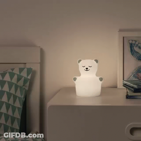 A Lamp In The Shape Of A Polar Bear Sits On A Nightstand GIF