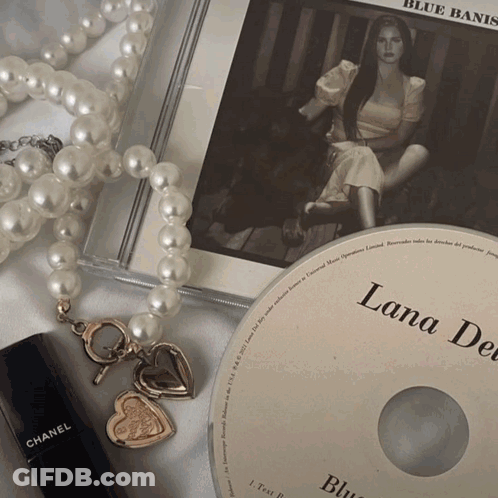 A Lana Del Rey Cd Sits On Top Of A Pearl Necklace GIF