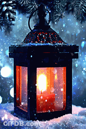 A Lantern With A Lit Candle Inside Of It Sits In The Snow GIF