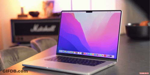 A Laptop Is Open On A Table With A Marshall Speaker Behind It GIF