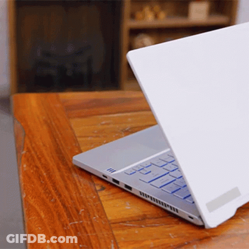 A Laptop Is Open On A Wooden Table GIF