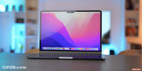 A Laptop With A Purple And Blue Screen Is Sitting On A Desk GIF