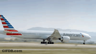A Large American Airlines Plane Is Taking Off From A Runway GIF