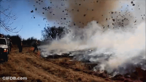 A Large Amount Of Smoke Is Coming Out Of A Fire In A Field GIF